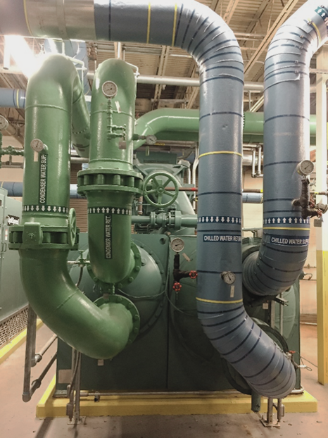 Industrial pipes in a water plant, featuring green and blue sections labeled 
